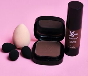 Flat lay of cosmetics including foundation bottle, compact, and sponges on pink background.